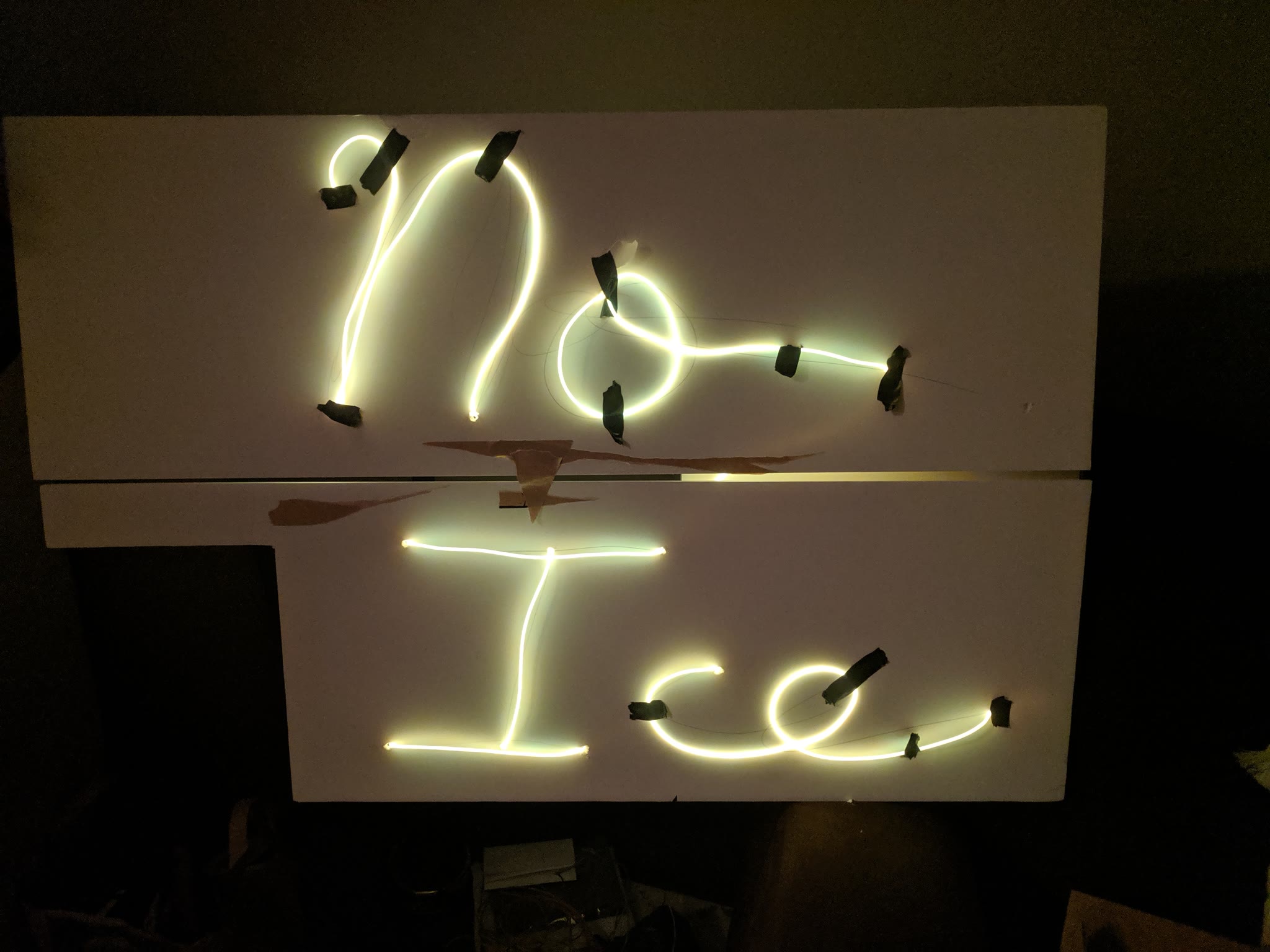 The prototype sign that says 'No Ice' in cursive is lit up with plain, poster-board backing.